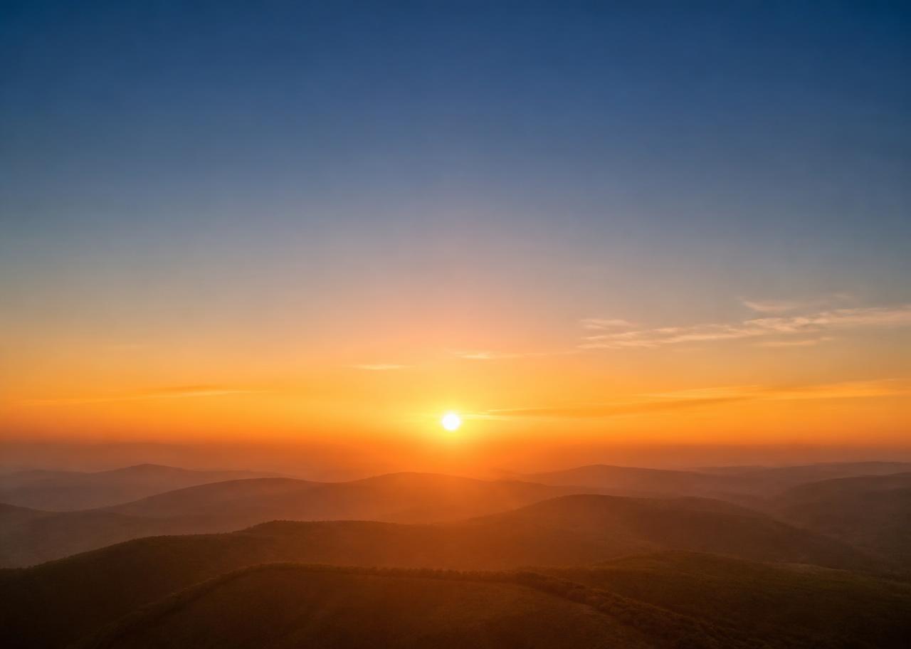 Golden light ascending over a calm landscape at dawn